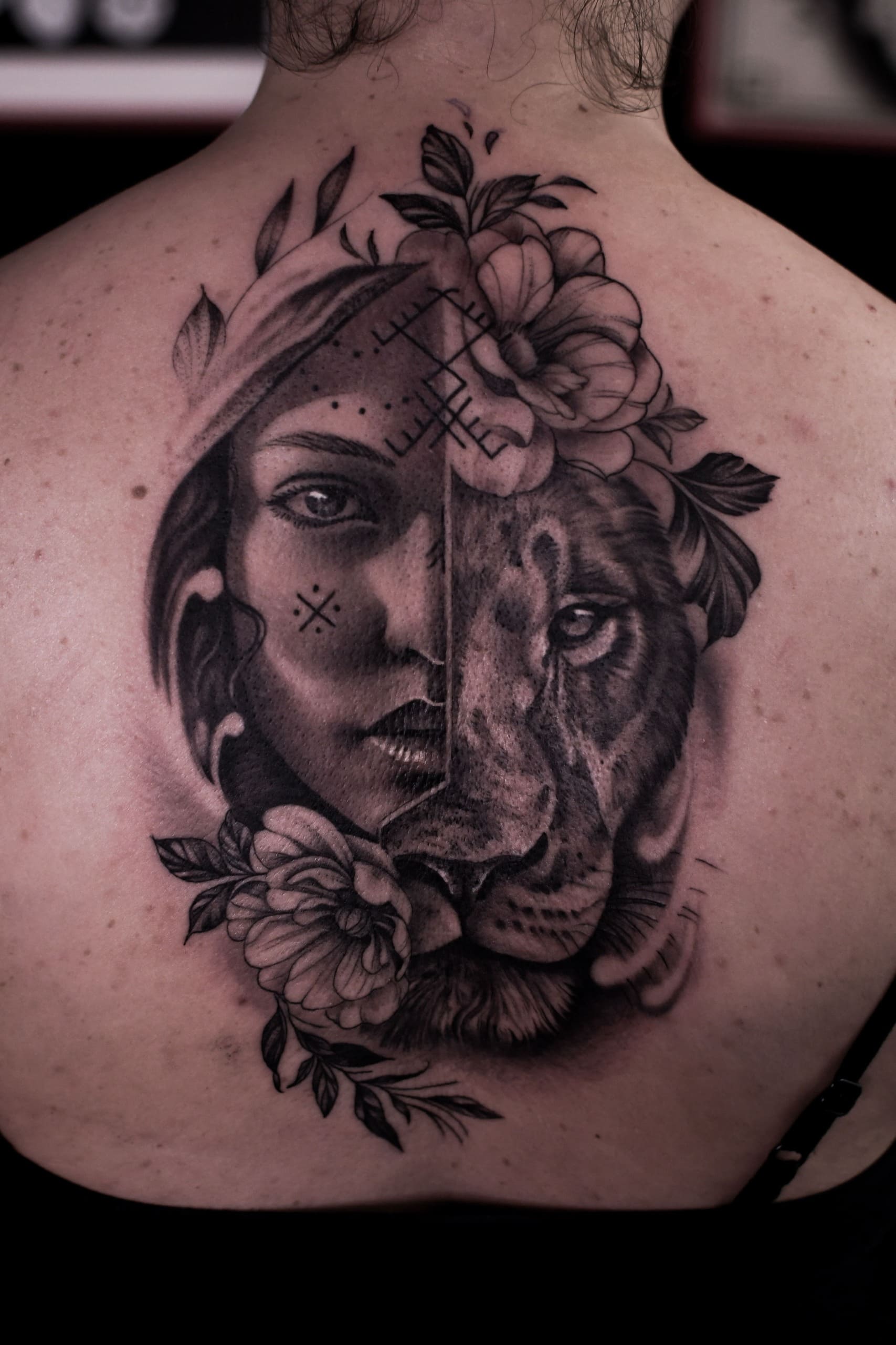 Tatouage dos réalisme noir et gris portait femme et lionne